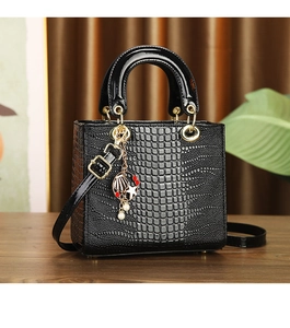 Detail of black crocodile embossed lacquer handbag with pearl and starfish charms