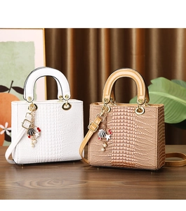 Detailed shot of crocodile-patterned handbags with luxury gold charms and hardware
