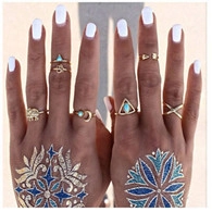 Detail shot of bohemian gold rings set with elephant motifs and turquoise stones on hand