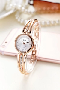 Detailed close-up of rose gold quartz watch with rhinestone bezel and Roman numerals