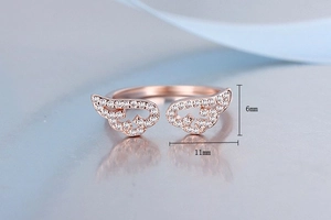 Macro view of rose gold angel wing ring with size specs 6mm height and 11mm width