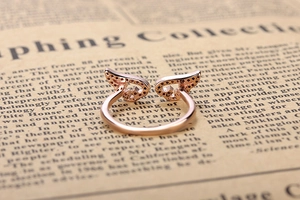 Detailed macro view of rose gold angel wing ring with sparkling crystal inlay details