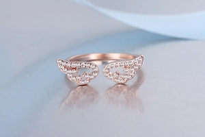Detailed macro view of a rose gold angel wing ring with sparkling inlaid diamonds