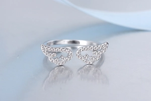 Macro detail of silver angel wing ring featuring sparkling pave-set stones on dual wings