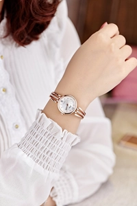 Detail of rose gold ladies' watch with rhinestone double chain strap on a model's wrist