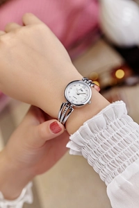 Close-up of silver quartz watch with rhinestone markers on a woman's wrist