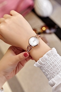 Detail of rose gold quartz watch with rhinestone hollowed-out metal strap on a wrist