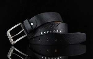 Detailed macro view of black textured leather belt with metal rivets and a silver buckle
