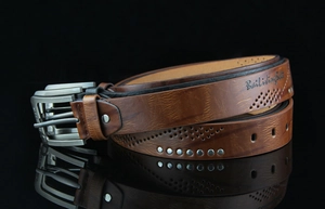 Detail of vintage leather belts in black and brown with metal rivets and pin buckles