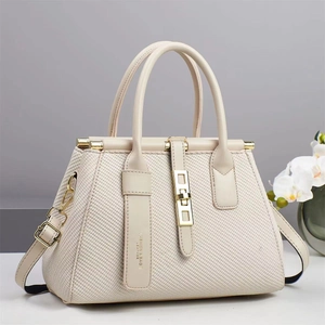 Detailed view of cream tote bag with twill texture and gold metal buckle accents