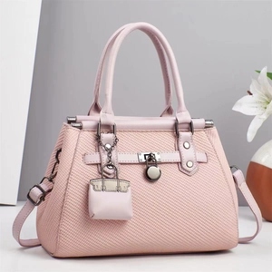 Close-up of pink crossbody bag featuring woven texture and silver metal clasp detail