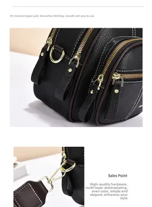 Detail of black textured leather bag featuring gold-plated hardware and white contrast stitching