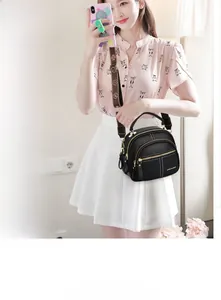 Detail of black pebbled leather crossbody bag with adjustable vintage pattern shoulder strap