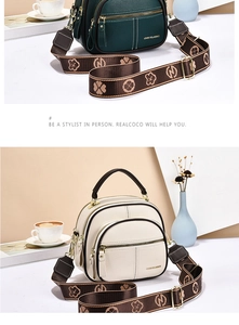 Detail view of multi-compartment leather shoulder bag with jacquard clover strap