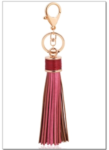 Detail of rose gold alloy hook with layered agate red leather tassel on white background