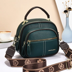 Dark green litchi leather shoulder bag with wide jacquard strap and gold hardware