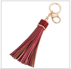 Close-up of burgundy leather tassel keychain with gold-tone metal ring and lobster clasp
