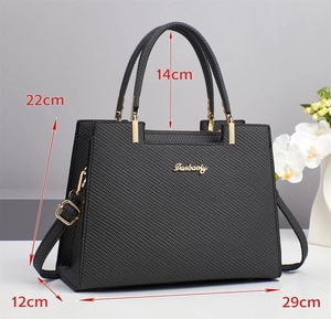 Detailed view of the black tote bag with gold hardware and removable shoulder strap