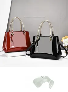 Detail of glossy patent leather tote bags with gold woven handles in burgundy and black