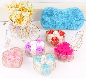 Detail view of five heart-shaped metal boxes filled with six colorful soap rose flowers