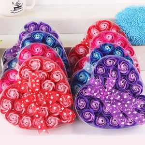 Macro shot of heart-shaped boxes with colorful soap flower roses and LOVE ribbons