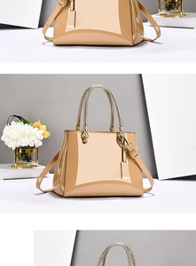 Close-up of beige patent leather tote bag with gold hardware and woven handle texture