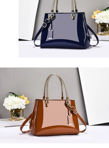 Detail of glossy patent leather tote bags with woven metal handles in navy and brown