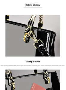 Detail of black patent leather tote bag with gold plated buckle and woven handle grip