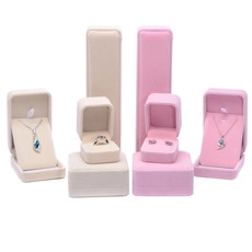 Close-up of pink and beige velvet jewelry boxes for rings, earrings and necklaces