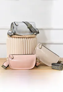 Dettaglio della trama in vera pelle e della tracolla larga a fantasia della borsa chic