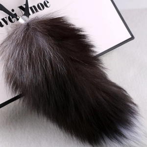 Macro shot of large faux fox tail keychain with long dense fur and silver metal clasp