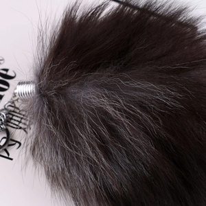 Macro view of dark brown real fox fur keychain texture and silver metal spring hook