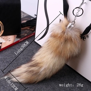 Detail view of large fox tail keychain in brown gradient with 30cm length specifications