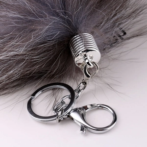 Close-up of the silver metal lobster clasp and chain on a fluffy grey fur keychain