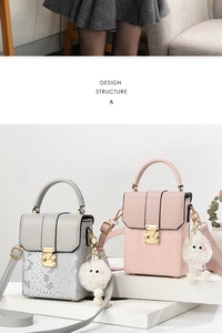 Detail showing snakeskin texture on mini flap bags with plush eye charms and metal clasp