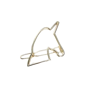Macro shot of minimalist gold unicorn head hair clip with hollow geometric metal lines
