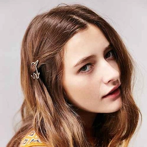 Golden minimalist cat-shaped hair clip shown on a model side profile in detail