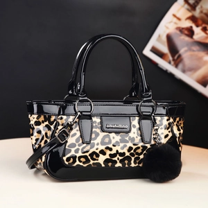 Chic leopard print crossbody handbag with black patent leather trim and a pompom charm