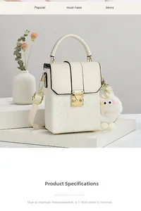 Detail of snake print crossbody bag with gold twist lock and pink fluffy charm