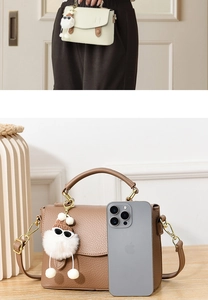 Détail du mini sac en cuir grainé avec charm poupée et téléphone pour comparer la taille