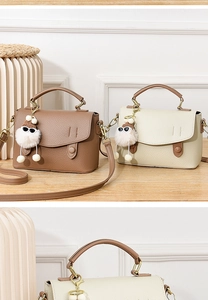 Détail du sac bandoulière en cuir texturé avec poignée et breloque en peluche mignonne
