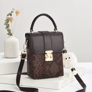 Snake embossed brown square crossbody bag with gold lock and plush pendant