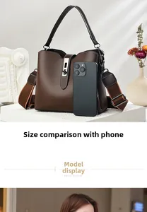 Dunkelbraune Leder-Beuteltasche neben einem Smartphone zum Größenvergleich gezeigt