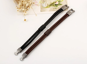 Close-up of vintage braided leather bracelets in black and brown with metal hook clasp
