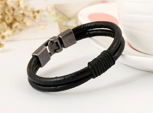 Close-up of black double-strand braided leather bracelet with silver magnetic metal clasp