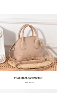 Détail du sac coquillage en cuir grainé avec zips dorés et bandoulière amovible