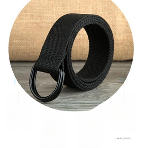 Detailed macro view of the double D-ring black matte metal buckle and canvas belt tip