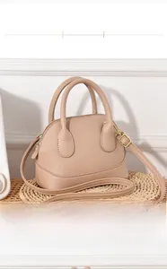 Détail de la texture cuir litchi rose du sac à main et des finitions dorées chic