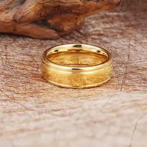 Classic polished gold tungsten ring for men featuring a stepped edge on wooden background