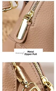 Gros plan sur la fermeture éclair dorée et le cuir grainé lychee du sac beige